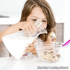 Girl pouring milk into a bowl of oats.