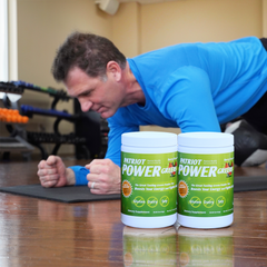 Man exercising with two double size canisters displayed.