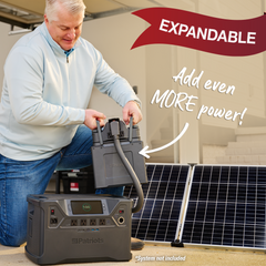 Man outside using the NEW Patriot Power Generator 2000X Expansion Pack attached to the Patriot Power Generator 2000X next to solar panel. Expandable and even more power!