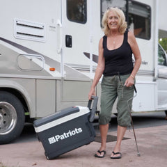 Women pulling the Freedom fridge next to an RV